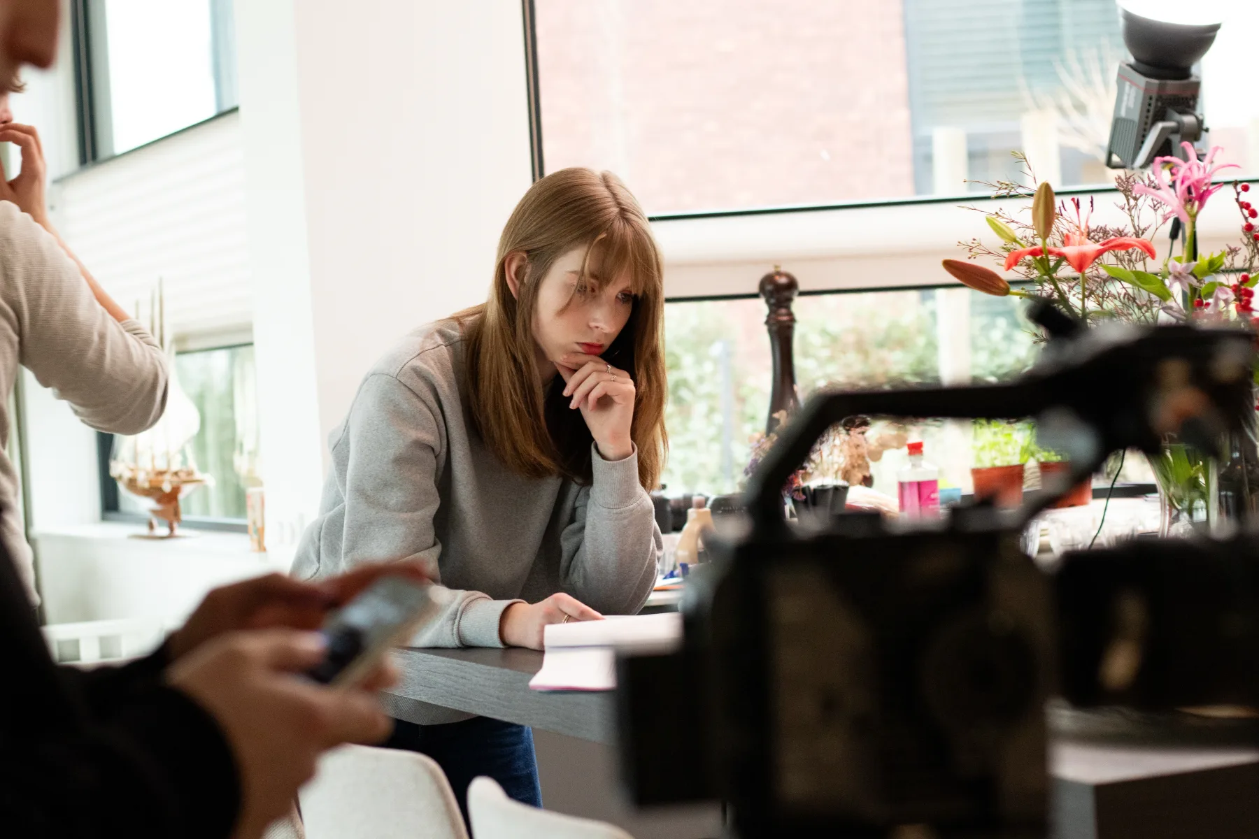 Acteur aan tafel gefilmd vanaf de cameraset